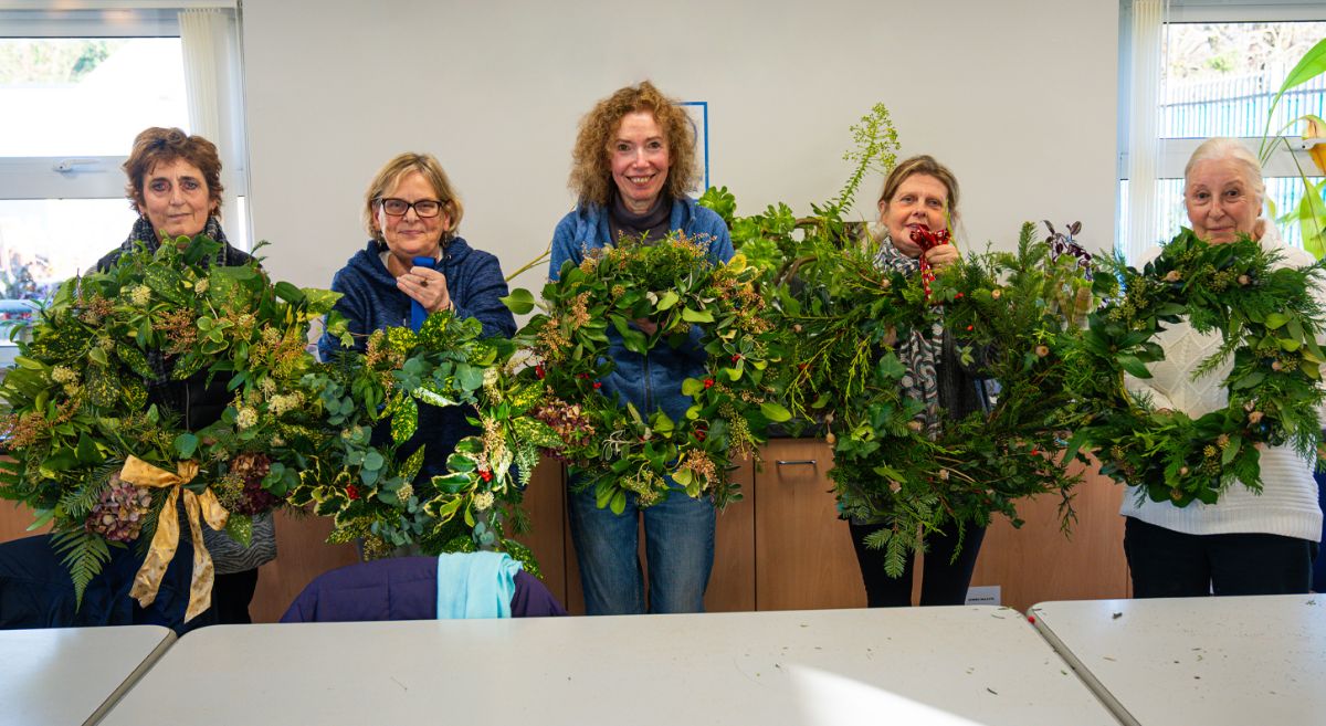 Horticulture students holding christmas wreaths